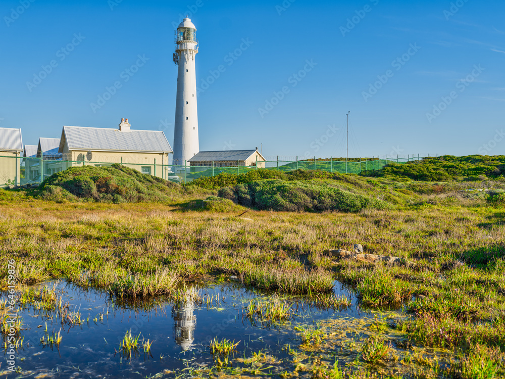 Slangkop Lighthouse and its reflection in the water during a clear afternoon, Kommetjie, Cape Town, South Africa