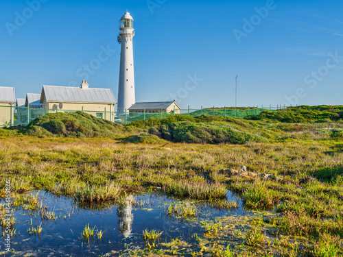 Slangkop Lighthouse and its reflection in the water during a clear afternoon, Kommetjie, Cape Town, South Africa