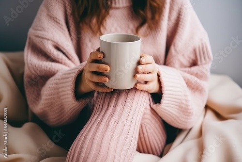 unrecognizable woman in a cozy winter home environment with cup of hot beverage in her hands