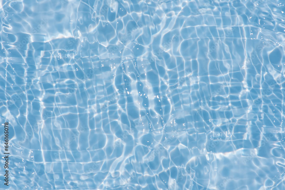 Obraz premium Blue water with ripples on the surface. Defocus blurred transparent blue colored clear calm water surface texture with splashes and bubbles. Water waves with shining pattern texture background.