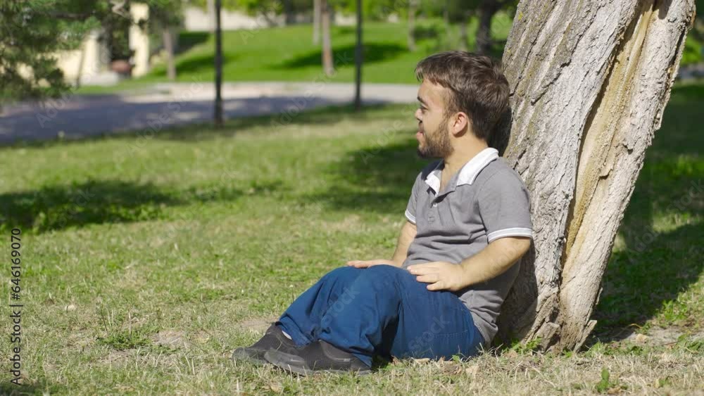 Dwarf young man sitting on the ground in panic. Dwarf young man sitting on the ground in panic.