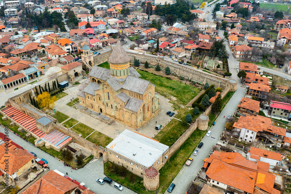 Aerial view of ancient Orthodox Svetitskhoveli Cathedral surrounded by defensive wall in historic Georgian town of Mtskheta on spring day