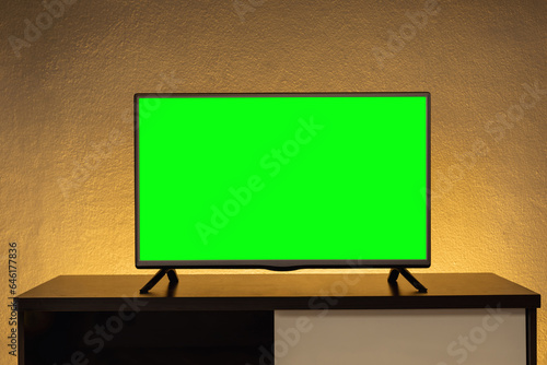 Obraz na plátně Modern 4K LCD television(TV) cut green chroma key on cabinet with yellow lights