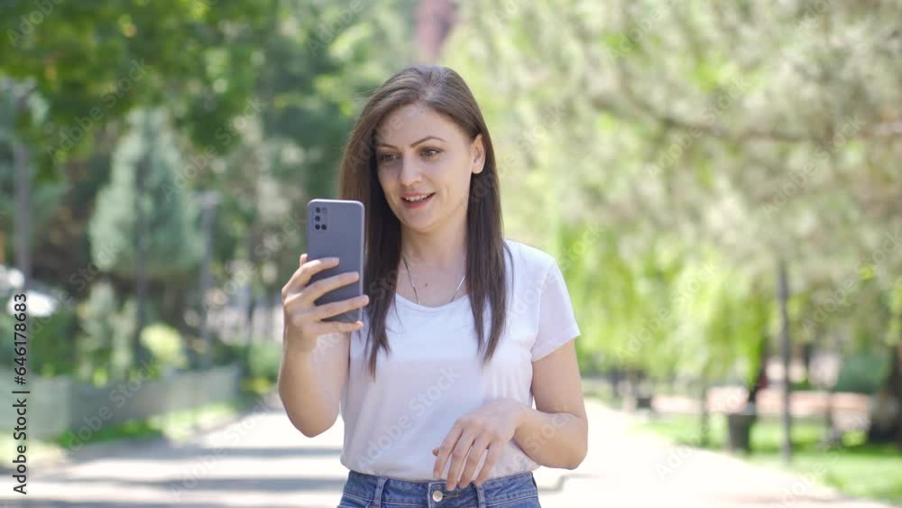 Woman making video call on phone outdoors. Woman making video call on phone outdoors.