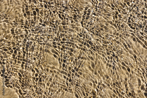 rippled water surface over a sand beach