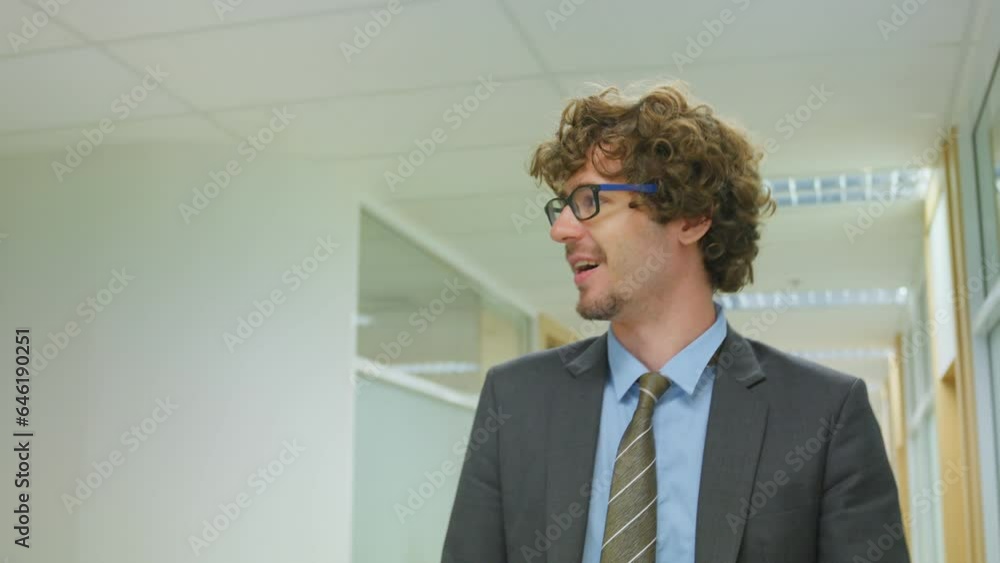 Caucasian businessman talk on phone while walk in corridor of office. Caucasian businessman talk on phone while walk in corridor of office.