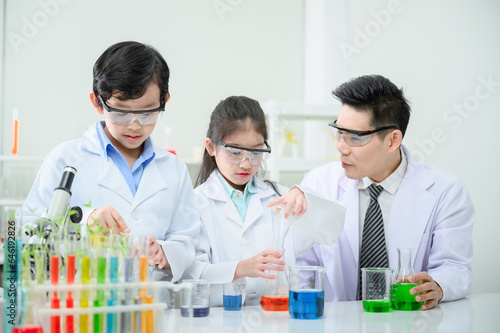 Male and female students and teachers work together to study test tubes in the studio.