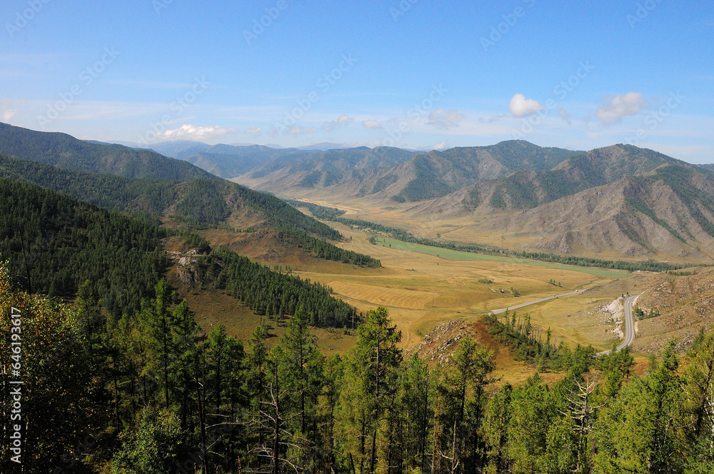 Looking from the top to the valley in the mountains which the paved road crosses, I make a wide turn. Looking from the top to the valley in the mountains which the paved road crosses, I make a wide turn.