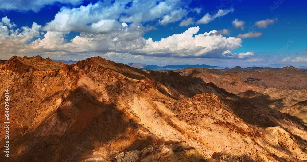 Amazing bare rocks of Mojave desert. Drone approaches the tops of mountains shaded by white clouds. Amazing bare rocks of Mojave desert. Drone approaches the tops of mountains shaded by white clouds.