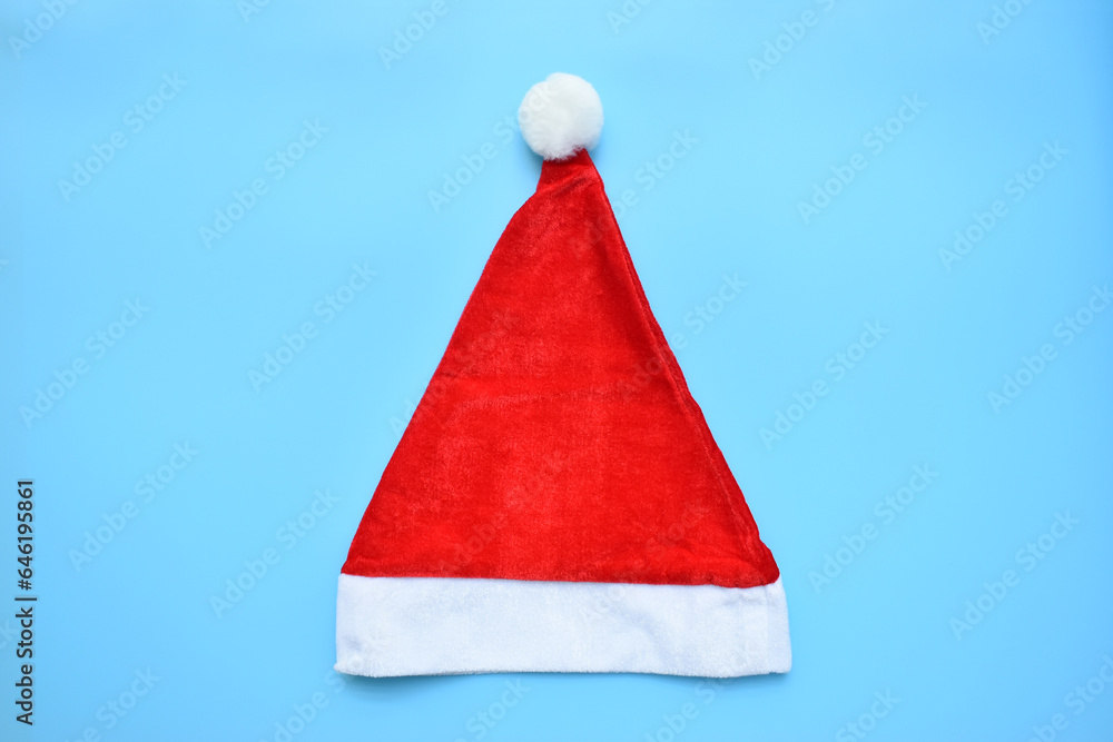 Santa claus red wool winter hat on blue background, christmas decoration Santa claus red wool winter hat on blue background, christmas decoration