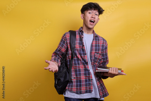 Young handsome Asian student in casual style showing greeting or welcoming gesture
