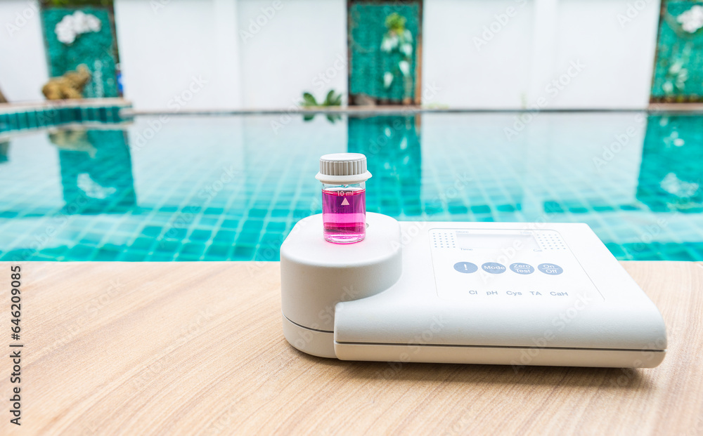 Quality water analysis tool on swimming pool edge with space on water background, measure chlorine and pH, pH testing with water photometer and reagent table