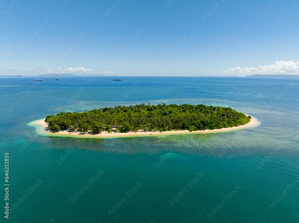 Eagles eye view of Island surrounded by blue sea and coral reefs. White sand all over the island. Mindanao, Philippines.