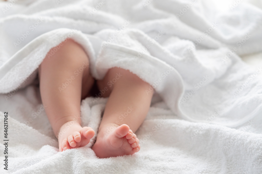 Baby's legs wrapped in a white towel's embrace. Concept of nurturing moments after bath Baby's legs wrapped in a white towel's embrace. Concept of nurturing moments after bath