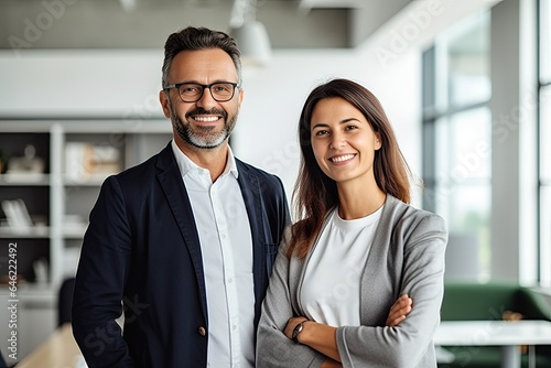 Male and female business couple posing smiling at their business office looking at the camera photo