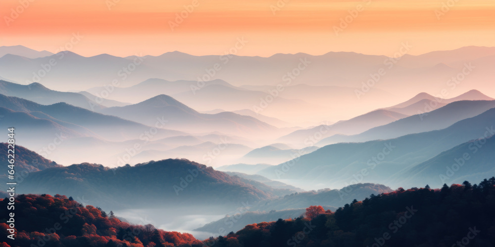 The mountains are shrouded in mist. A twilight shot of autumn mountains under a fading red orange purple sky.