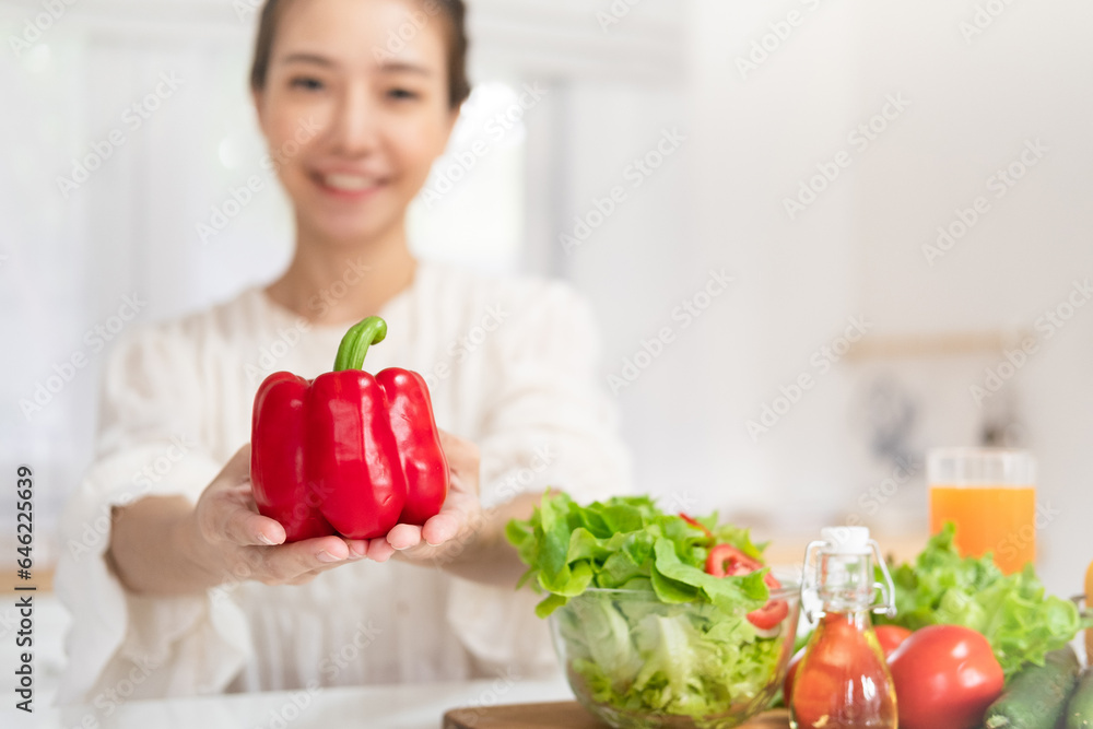 Beautiful smiling healthy woman with bell pepper in her hands while preparing vegan food. Proper nutrition. Beautiful smiling healthy woman with bell pepper in her hands while preparing vegan food. Proper nutrition.