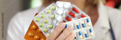 Valokuva Female pharmacist holds in her hand many packages of medical pills