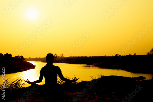 Silhouette of woman praying over beautiful sky background  © Janpen