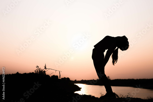Silhouette of woman praying over beautiful sky background  © Janpen