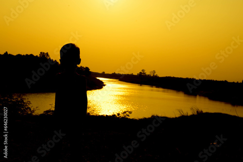 Silhouette of a family comprising a father, mother and two children happy family the sunset.Concept of friendly 