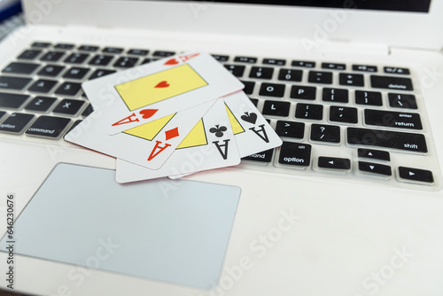 Playing cards above white laptop for online poker game