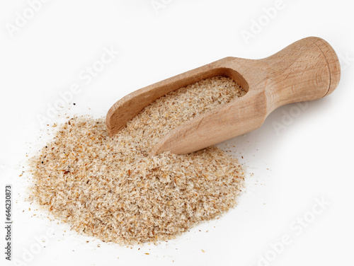 heap of psyllium husk in wooden scoop isolated on white background, Plantago Indica seed pods for use as fiber for the keto diet photo
