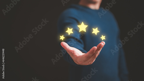 Customer hand showing the stars to complete five stars. Comment scores are good. Customer service assessment  testimonial  feedback  giving a five star rating. Service rating  satisfaction concept.