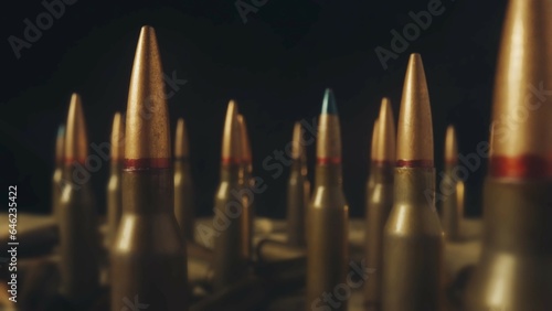 Rows of numerous rifle cartridges on a black background close up. The concept of firearms, shooting range, production and trade of ammunition.