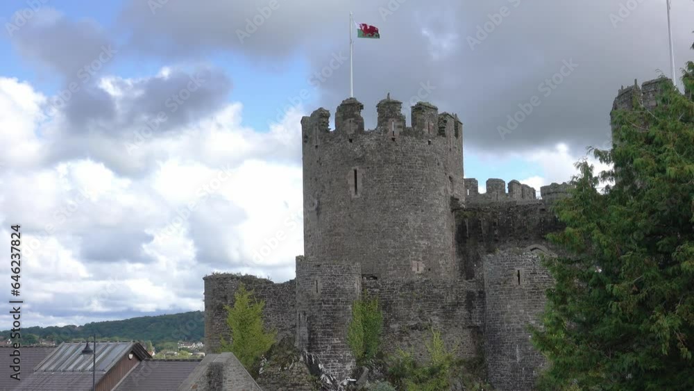 A majestic large stone castle towers over the medieval village of Conwy Wales A majestic large stone castle towers over the medieval village of Conwy Wales