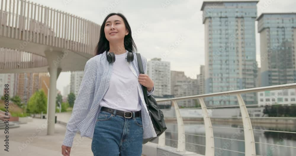 Attractive young asian woman with headphones walking at the city Attractive young asian woman with headphones walking at the city