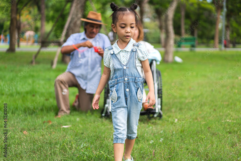 Obraz premium Portrait of happy love asian grandfather with grandmother and asian little cute girl enjoy relax in summer park.Young girl with their laughing grandparents smiling together.Family and togetherness