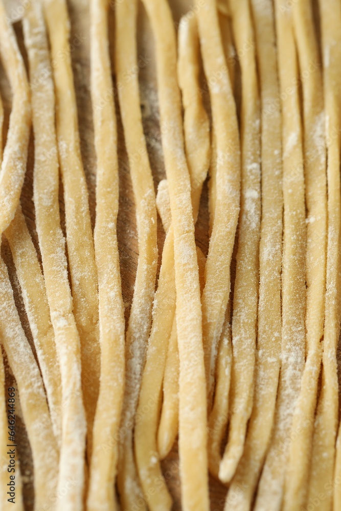 Raw homemade pasta and flour on wooden table, closeup Raw homemade pasta and flour on wooden table, closeup
