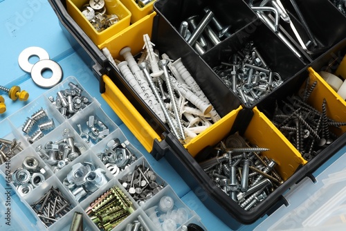 фотографія Organizers with many different fasteners on light blue wooden table, above view