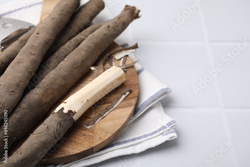 Raw salsify roots on white tiled table, closeup. Space for text photo