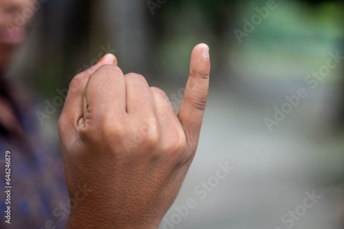 A boy shows his little fingers with his hands clenched into fists © Rokonuzzamnan