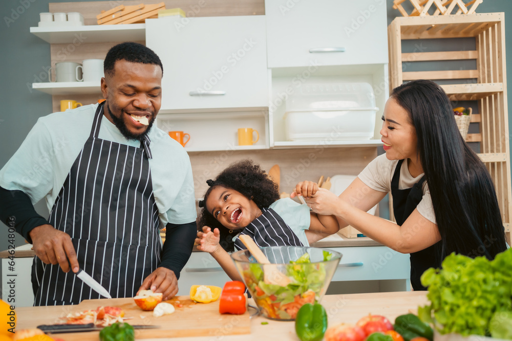 Kind African american parents teaching their adorable daughter how to cook healthy food, free space of kitchen, Happy black people family preparing healthy food in kitchen together