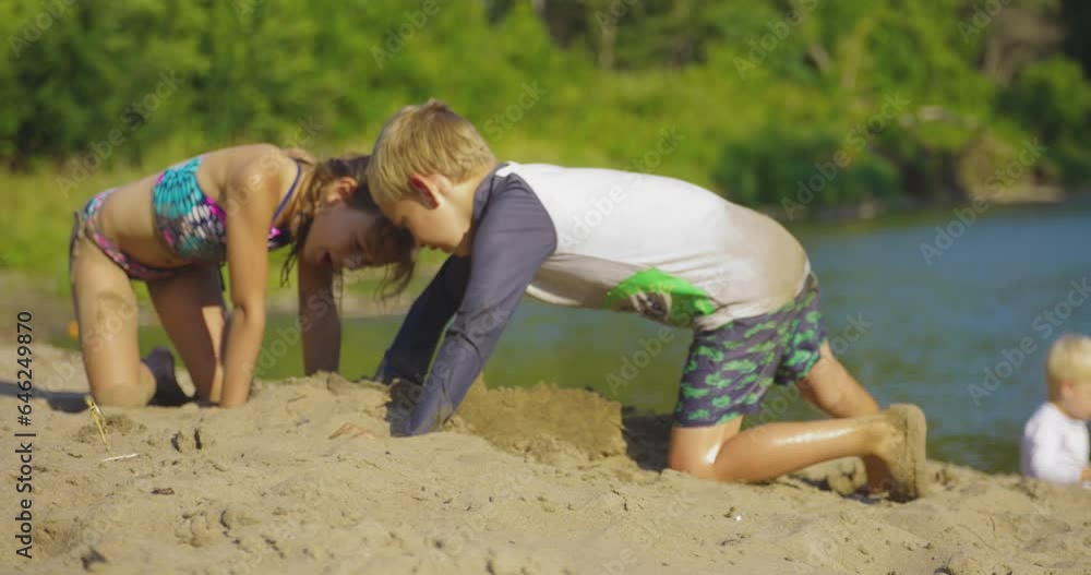 Children Playing Sand On The Rivershore During Sunny Day. Close Up Children Playing Sand On The Rivershore During Sunny Day. Close Up