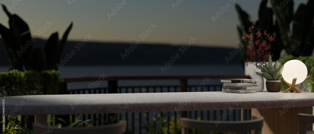 Fototapeta premium Copy space on a tabletop on a balcony with tropical plants and a beautiful nature view at night.