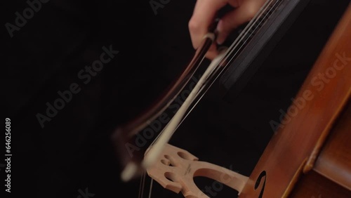 close up of woman playing staccato on the cello