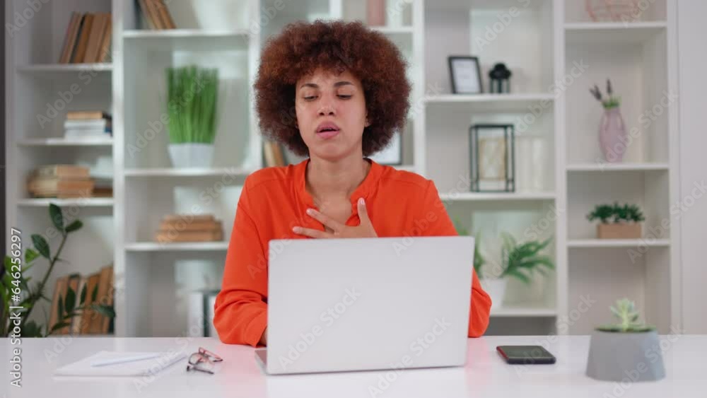 Multicultural young woman with curly hairstyle suffering from severe chest pain during panic attack at workplace. Company female worker having breathing problems during uncontrollable stress. Multicultural young woman with curly hairstyle suffering from severe chest pain during panic attack at workplace. Company female worker having breathing problems during uncontrollable stress.