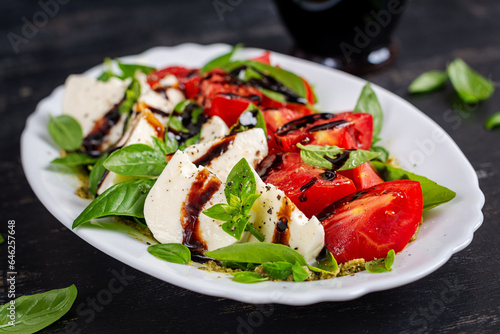 Caprese salad tomato for concept design. Dark background, close up. Food concept.