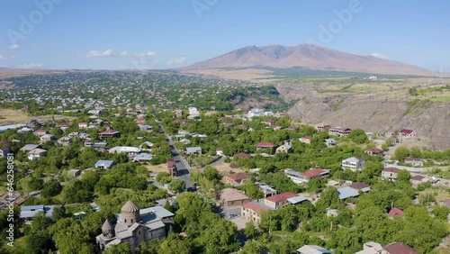 Backward revel drone footage of Saint Gevork Monastery, Mughni village and Mount Ara on sunny summer day. Aragatsotn Province, Armenia. photo