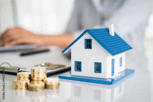 Real estate or property investment. Home mortgage loan rate. Saving money for retirement concept. Coin stack with house model on table. Business growth background