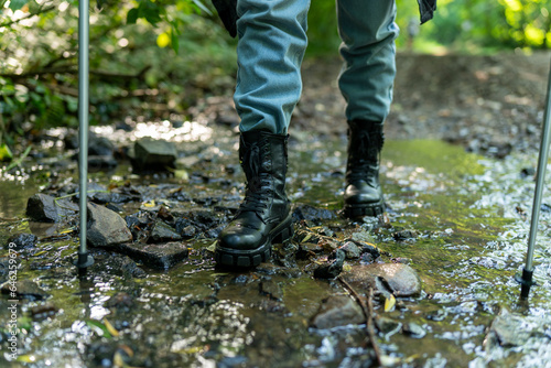 close up image of boots walking through water, hiking concept
