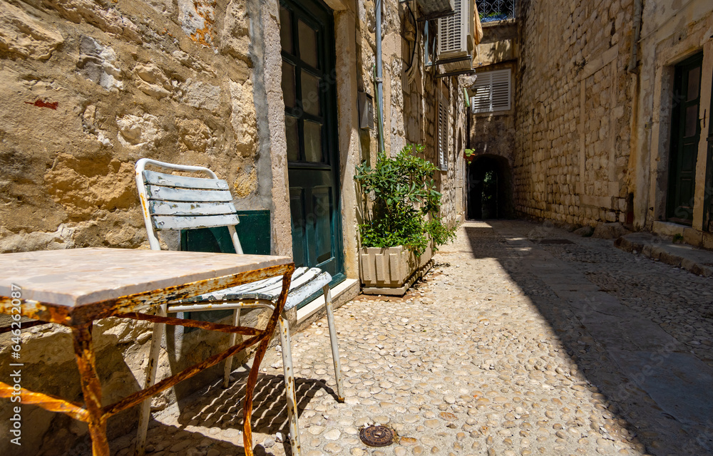 table and chair at entrance to the old house, street view of the old town Dubrovnik, Croatia, medieval European architecture, narrow streets in historic city