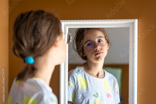 Photography A teenage girl looks at herself in the mirror in the morning.