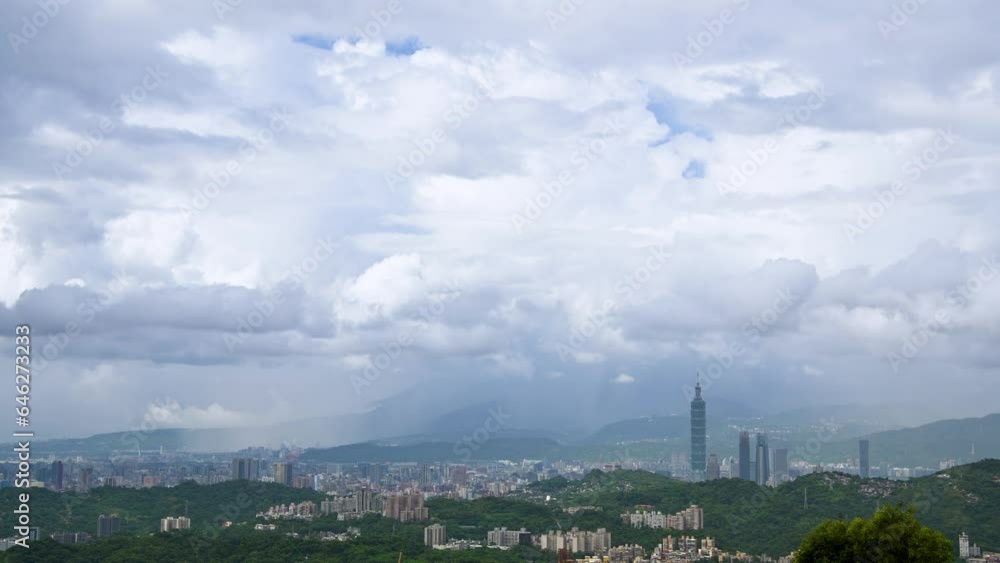 Dynamically changing and diverse layers of white clouds over the city. White clouds, green mountains and city buildings form a picture. Dynamically changing and diverse layers of white clouds over the city. White clouds, green mountains and city buildings form a picture.