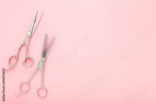 Canvas Print New professional hair scissors and thinning shears on light pink table background