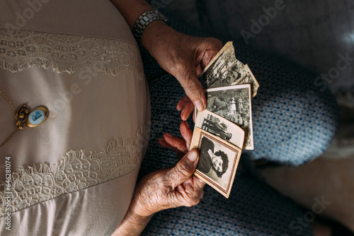 Senior woman holding photographs from past at home